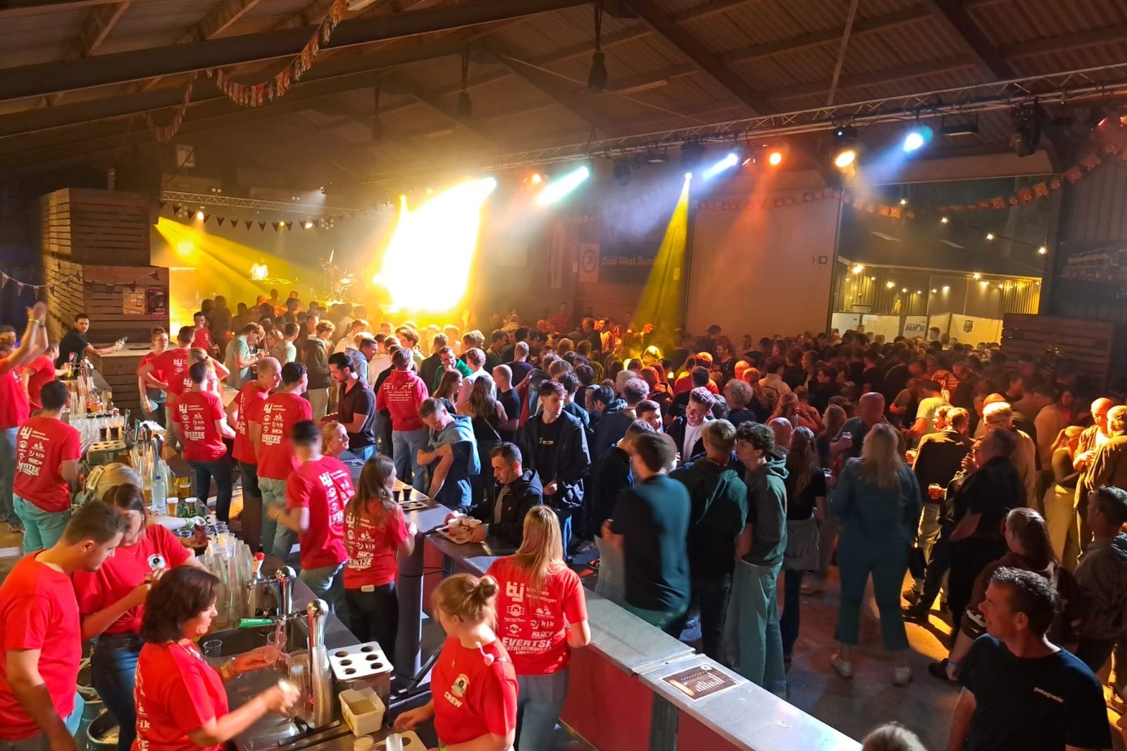 Volle schuur met het podium en de tap tijdens het Schuurfeest